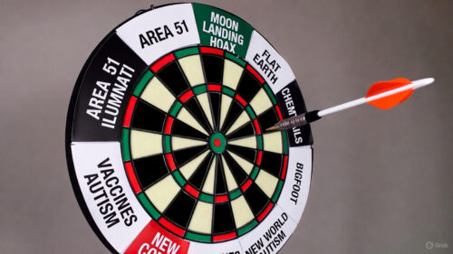 Dartboard labeled with conspiracy theories from AJ Gentile interview, including moon landing hoax and Area 51, with an arrow flying mid-air