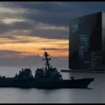A US Navy destroyer sailing past a massive, ominous server monolith glowing with code in the ocean at sunset, symbolizing tech narrative manipulation